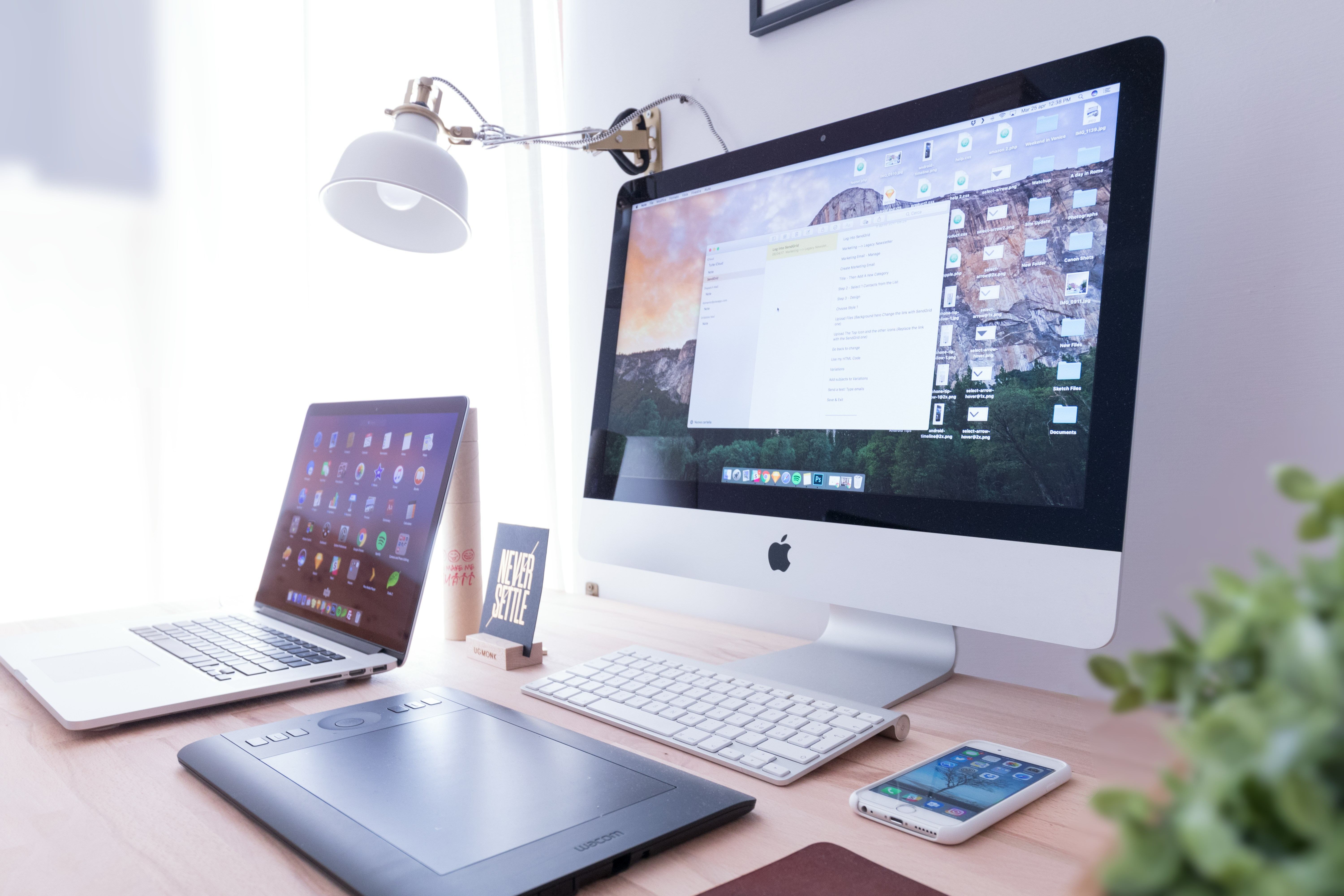 desk with computer monitor and laptop on it